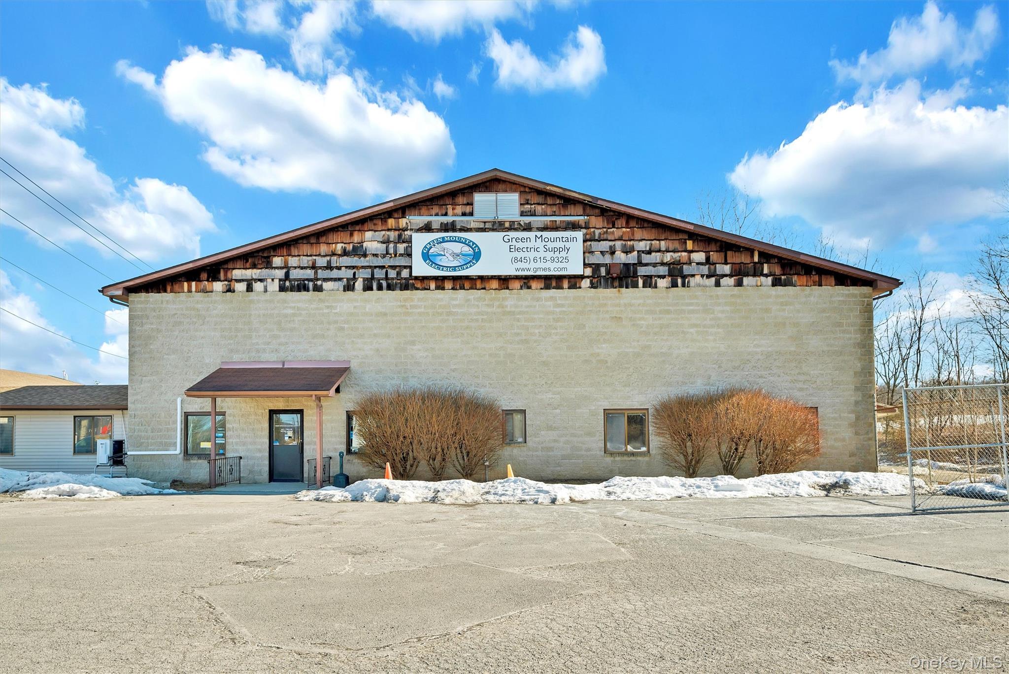 View of building exterior featuring central AC unit