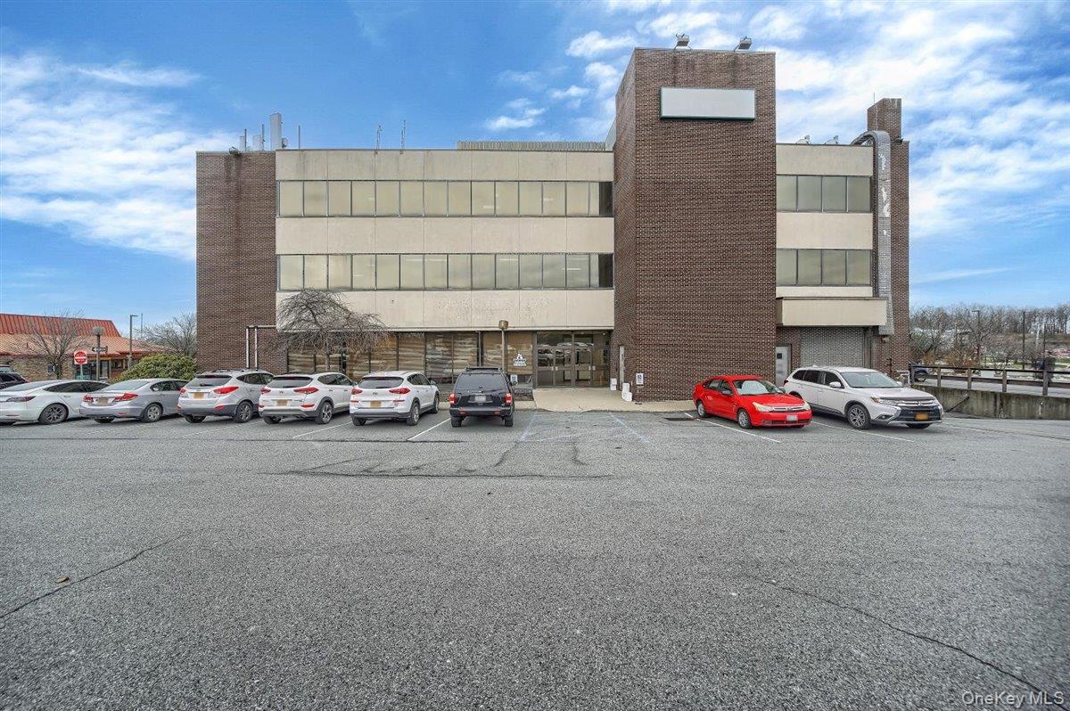 View of property with uncovered parking