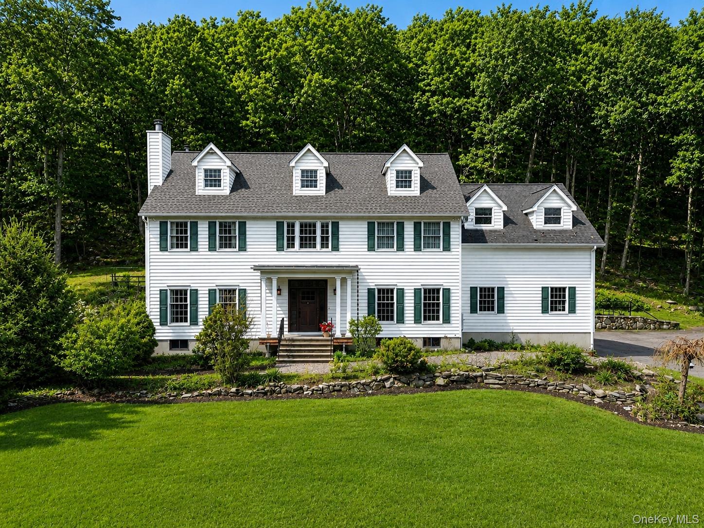 Classic white Colonial withgreen shutters set on apeaceful, wooded lot, offeringtimeless curb appeal andserene surroundings. Virtually edited for Summer
