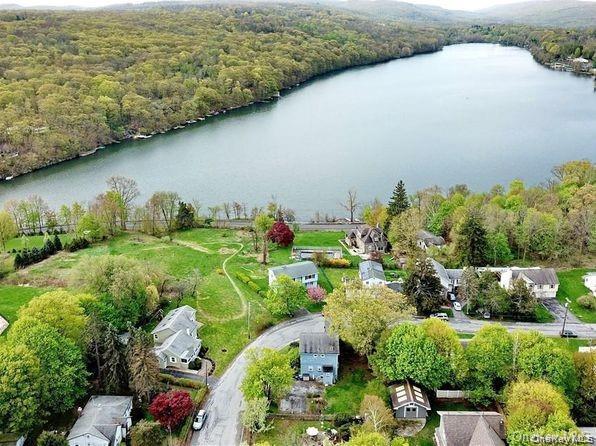 Aerial view of residential area featuring a heavily wooded area and a nearby body of water