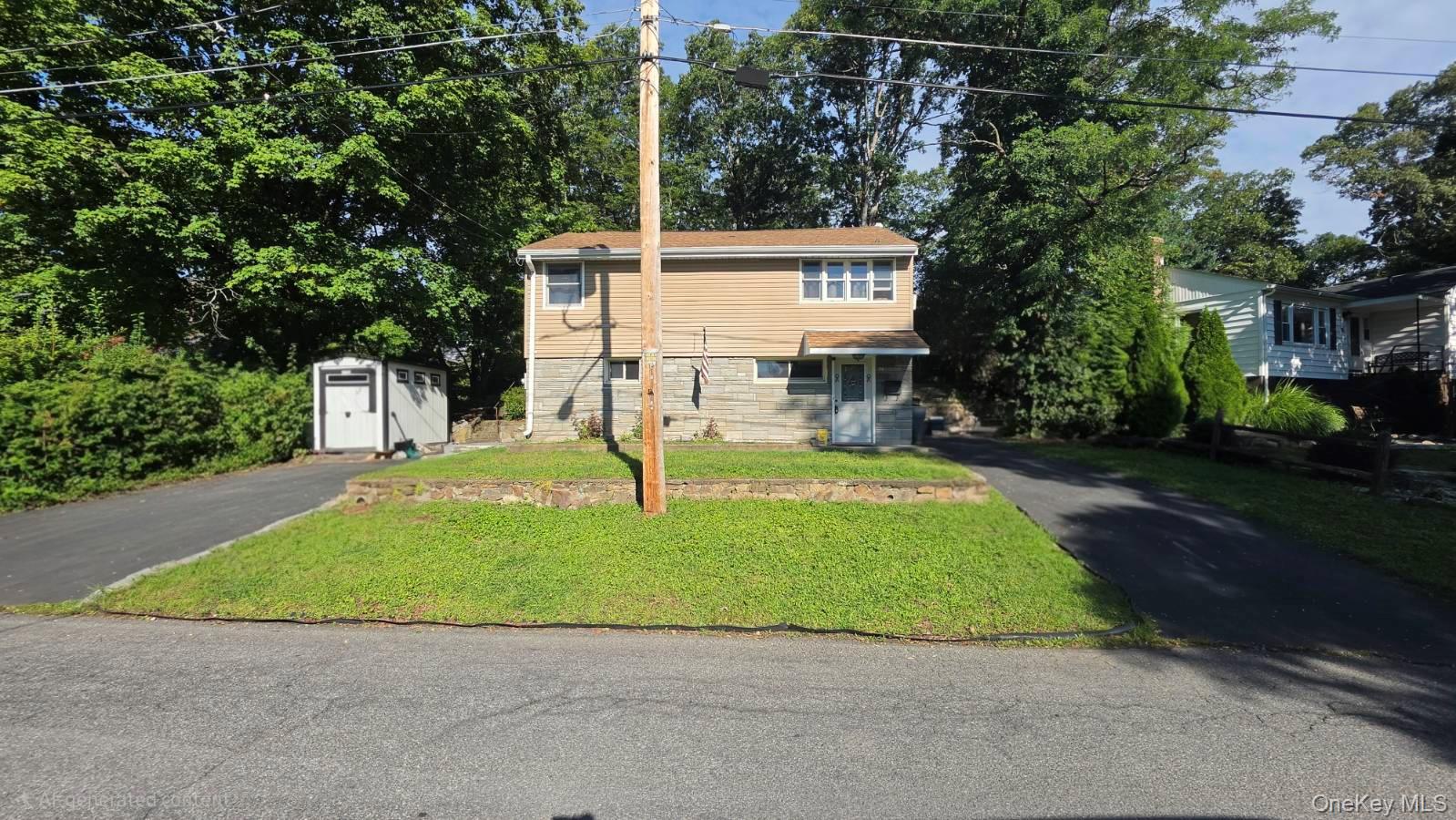 Two asphalt driveways, a front lawn, a detached storage shed, and a covered entry