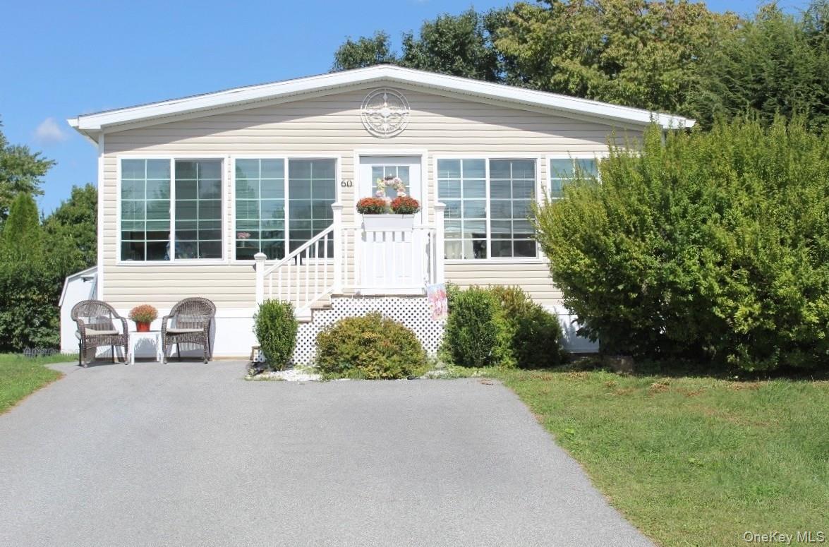 Single-story residence featuring light-toned horizontal siding and a prominent front entrance.with white railings