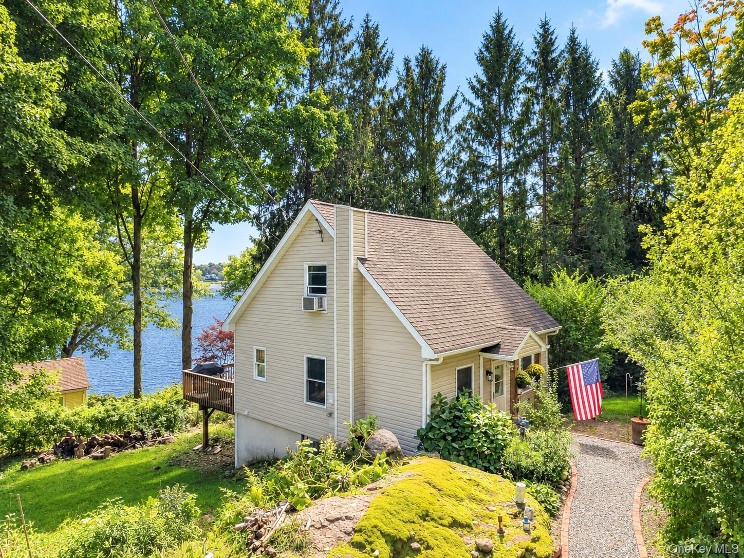 View of garden (left center of photo), house to the right and lake behind from front corner of off street parking area