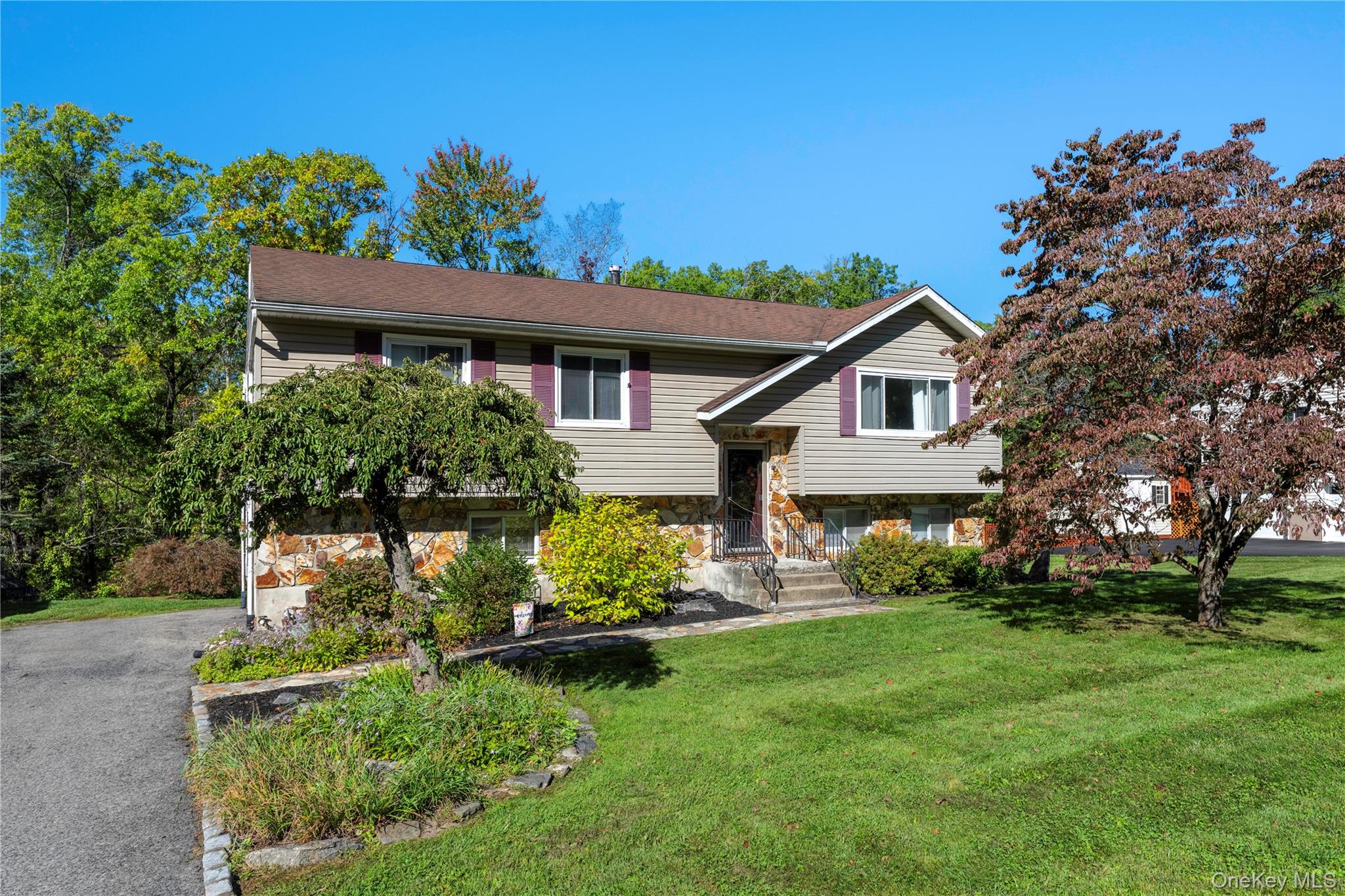 3 Bedroom home featuring stone and siding exterior, a brown shingle roof, and a paved driveway