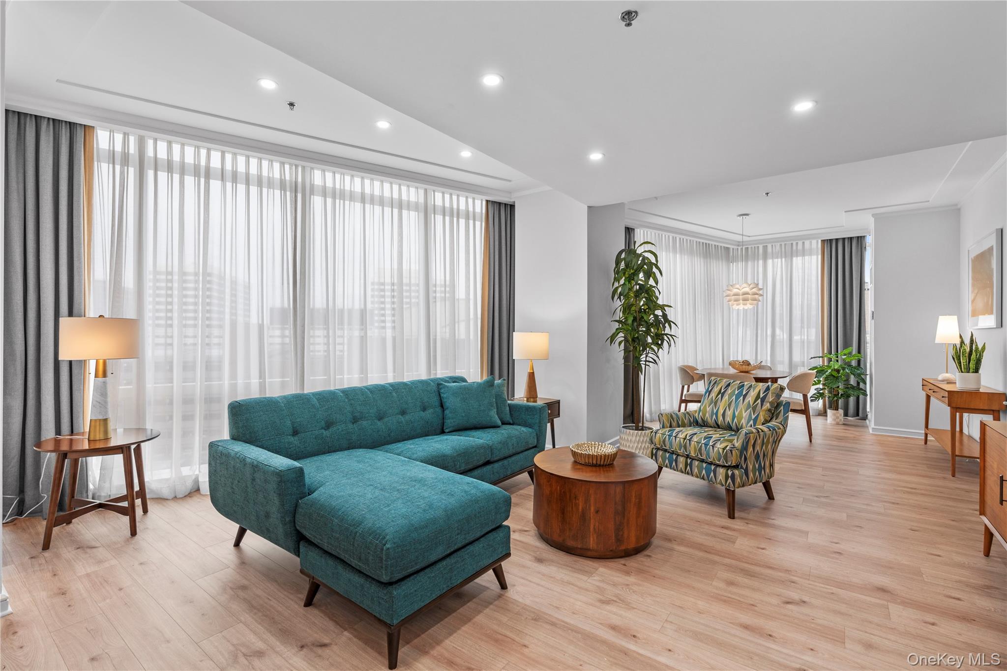 Living area featuring a wall of windows, recessed lighting, and light wood-style floors
